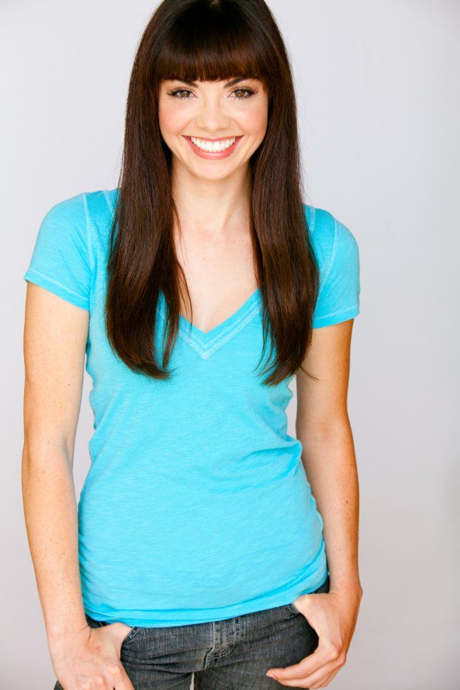 Annemarie Pazmino smiling while her hands on her pocket and wearing a sky-blue t-shirt and denim pants